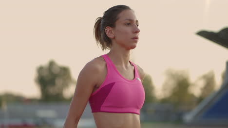 Atleta-Femenina-Comenzando-Su-Sprint-En-Una-Pista-De-Atletismo.-Corredor-Despegando-Desde-La-Parrilla-De-Salida-En-La-Pista-De-Atletismo.-La-Joven-Atleta-Comienza-A-Correr-Desde-El-Bloque.-Camara-Lenta